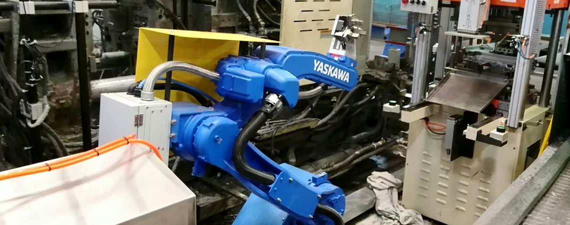 Il braccio robotico YASKAWA motoman GP25 sta aspettando il pressa idraulica per eseguire forature e tagli.